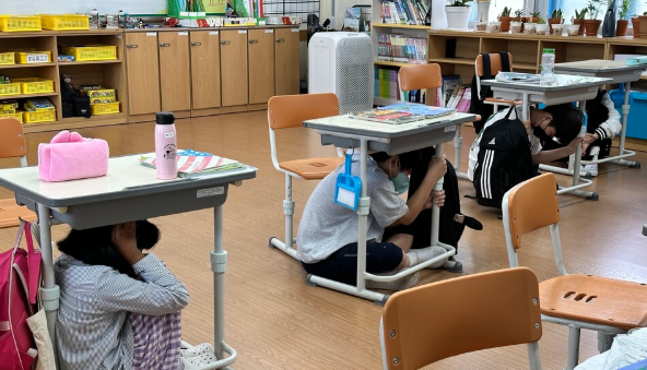 책상 밑으로 대피하는 학생들